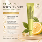 A tube of Vitamin C Booster Shot face cream moisturizer stands on a gold tray beside sliced orange halves and gold capsules, with marketing text and benefit callouts on a warm beige background.